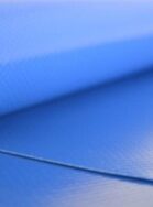 Close-up of a rolled blue exercise mat with textured surface and visible edge.