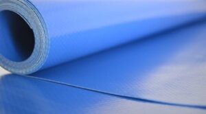 Close-up of a rolled blue exercise mat with textured surface and visible edge.