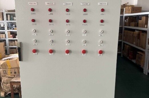 Industrial electrical control panel with numerous red pushbuttons and white indicators arranged in a grid, in a warehouse setting.